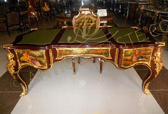 A marvelous French 19th century Louis XV and Vernis Martin style ormolu-mounted veneer inlaid Executive decorative Bureau Plat, the scalloped surface with moulded border cornered at the four angles with gilt ormolu foliate lyre and seashell shaped cast clasps and three sectional scalloped gilt-tooled leather top, the frieze below has five drawers, with delicate foliate handles, and all bordered with intricately chiseled foliate ormolu trims, the central recessed drawer with foliate ormolu keyhole escutcheons. On each side of the central drawer, vertical acanthus gadroon shaped ormolu chutes elongated with ormolu fillet wrapping around the contour of the whole desk, at each corner extraordinary and richly chiseled large gilt-ormolu female figure chutes adorned with scrolls and a feather headdress, the sides with finely ornamented with foliate scrolled ormolu encadrements terminated with C shapes harmonized with the scalloped apron below, the drawers, the sides and the back are beautifully hand painted by our artisans with romantic court scenes and outdoor natural landscapes on the François Boucher manner, the desk is raised on four bold cabriole legs with exquisitely chased ormolu leafy paw sabots